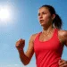 A fit woman exercising outdoors in hot sunny weather to burn more calories in the heat.