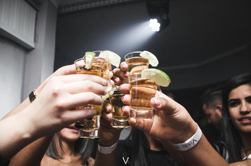 Group of people celebrating with shot glasses, highlighting the legal drinking age in Puerto Rico, which is 18.