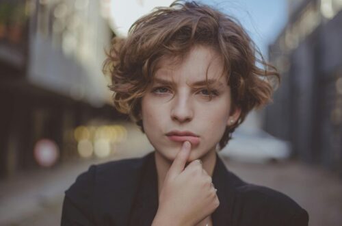 Young woman standing confidently with short layered hair, styled neatly and effortlessly.