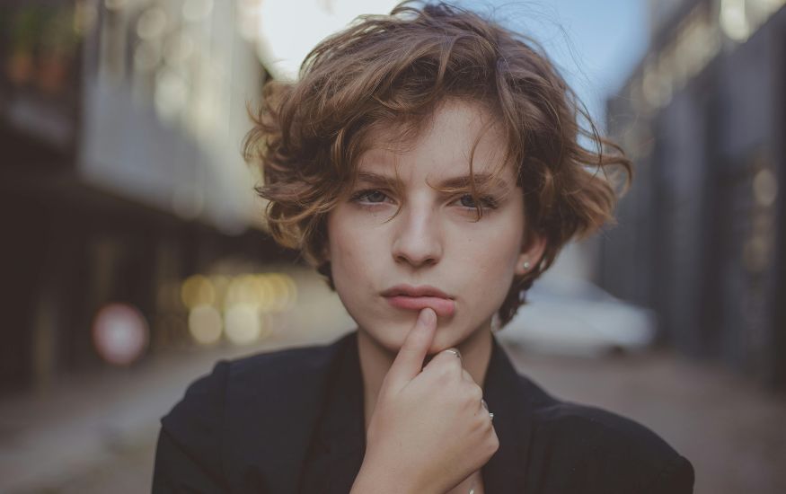 Young woman standing confidently with short layered hair, styled neatly and effortlessly.