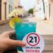 Do You Have to Be 21 to Drink in Puerto Rico? Glass with tag reading “21 Legal Age to Drink Puerto Rico” held by hand