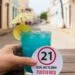 Do You Have to Be 21 to Drink in Puerto Rico? Glass with tag reading “21 Legal Age to Drink Puerto Rico” held by hand