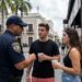 Is Puerto Rico Strict on the Drinking Age? A police officer in Old San Juan speaks with two young adults holding cups near a sign that states the minimum drinking age is 18.