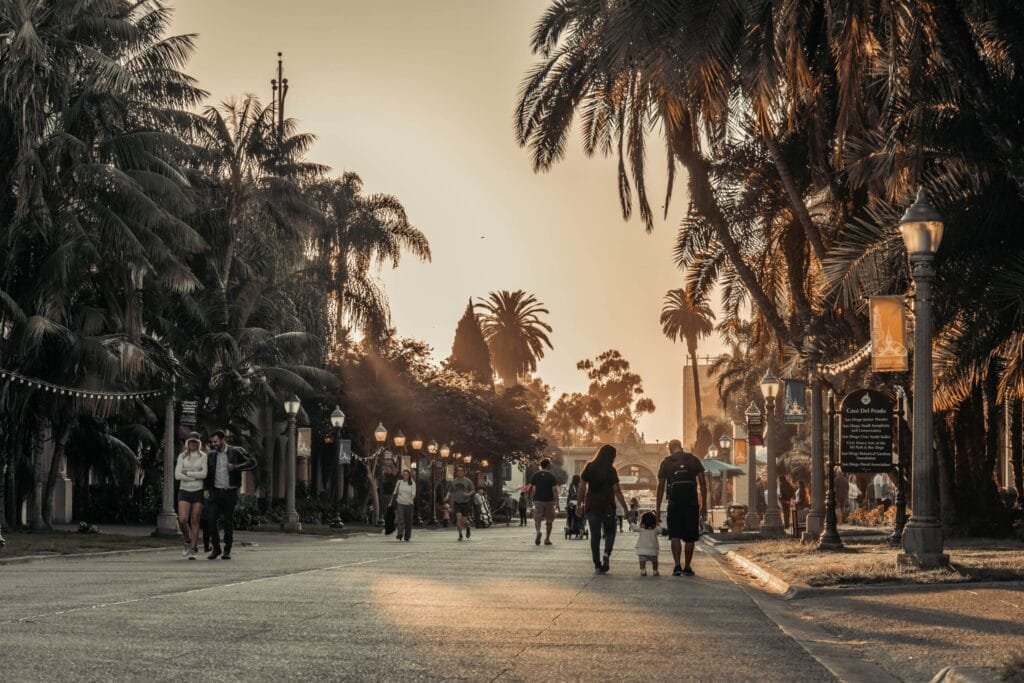 People strolling down a palm-lined walkway, exploring fun things to do in Newport Beach.